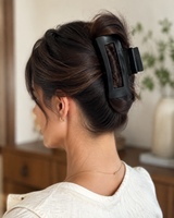 Black rectangular claw clip holding a brunette French-twist hairstyle, viewed from behind.
