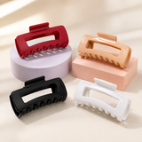 Cherry red, Caramel, Black and White flexible rectangular hair clips on pastel display blocks